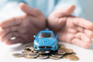 Comparateur assurance auto pas chère – véhicule miniature sur des pièces de monnaie