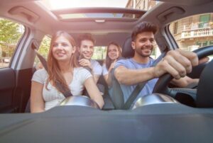 Jeunes conducteurs heureux en voiture après avoir obtenu un devis d’assurance auto